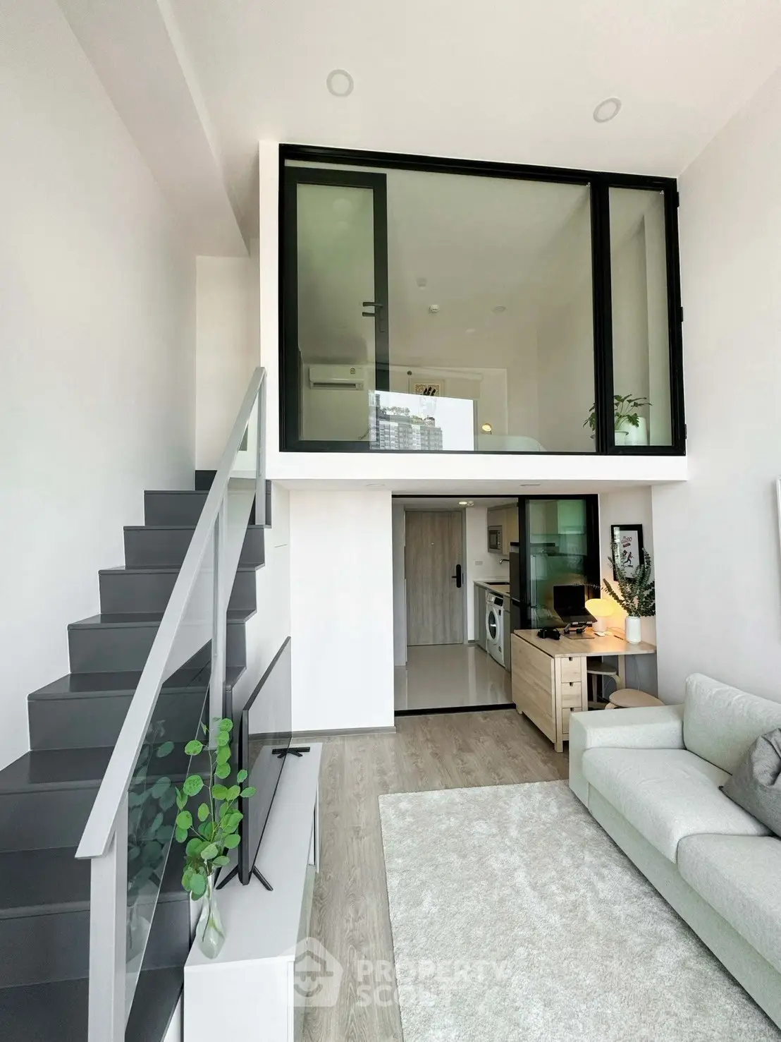 Modern loft apartment with mezzanine, sleek staircase, and stylish living area