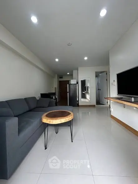 Modern living room with sleek furniture and wall-mounted TV in a stylish apartment.