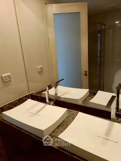 Modern bathroom with dual sinks and elegant fixtures in a stylish real estate property.
