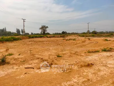 Expansive vacant land with potential for development under clear skies.