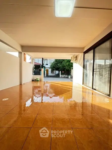 Spacious tiled patio with natural light, perfect for outdoor gatherings.