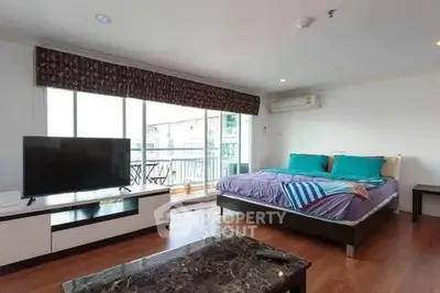 Spacious bedroom with balcony access and modern furnishings in a stylish apartment.