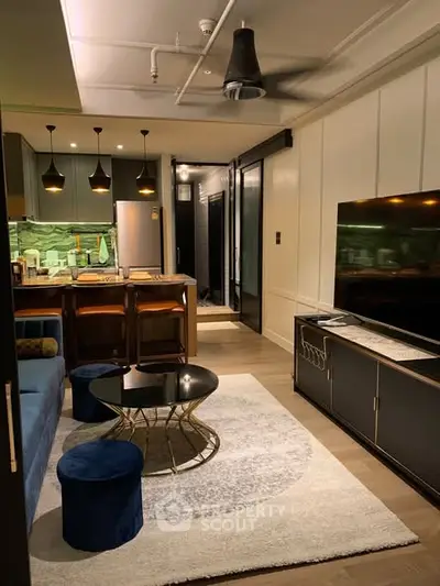 Modern living room with stylish furniture and open kitchen layout, featuring elegant lighting and contemporary decor.