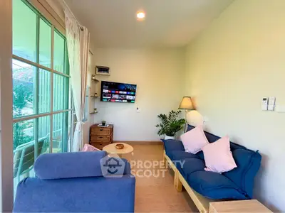 Charming living room with cozy seating and large window offering scenic views.