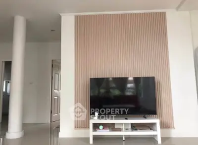 Modern living room with stylish TV setup and elegant wall paneling