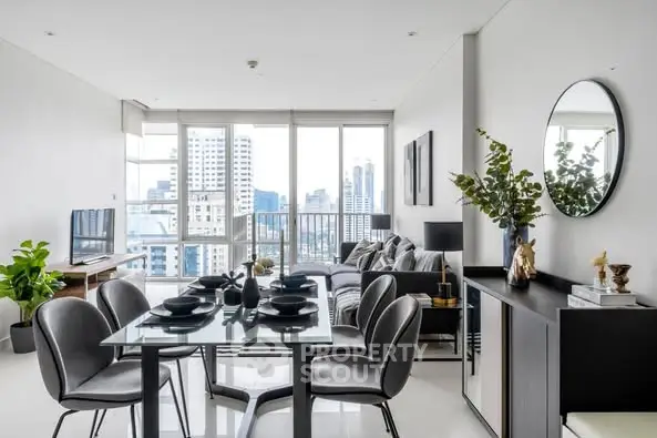 Modern open-plan living and dining area with city view, stylish decor, and abundant natural light.