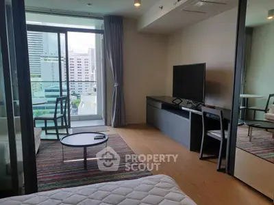Modern living room with city view, sleek furniture, and large TV in a high-rise apartment.