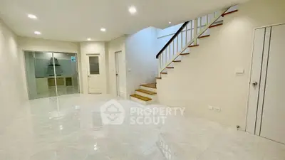 Spacious modern living room with staircase and sleek tile flooring