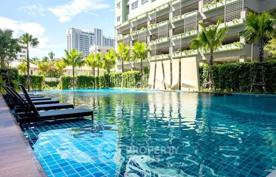 Luxurious condominium pool area with lush greenery and modern architecture.