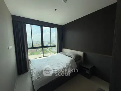 Modern bedroom with large window offering stunning city view