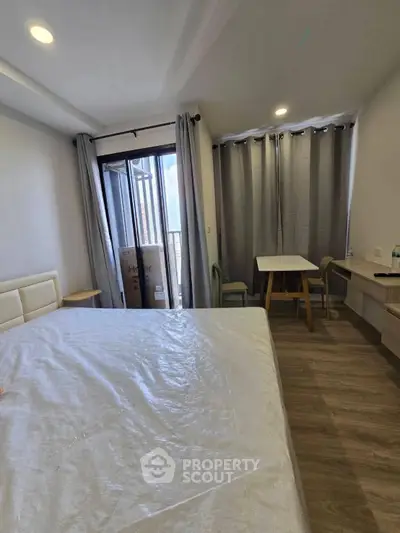 Modern bedroom with balcony access and stylish furnishings in a high-rise apartment.
