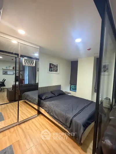Modern bedroom with glass walls and wooden flooring, featuring a cozy bed and stylish decor.
