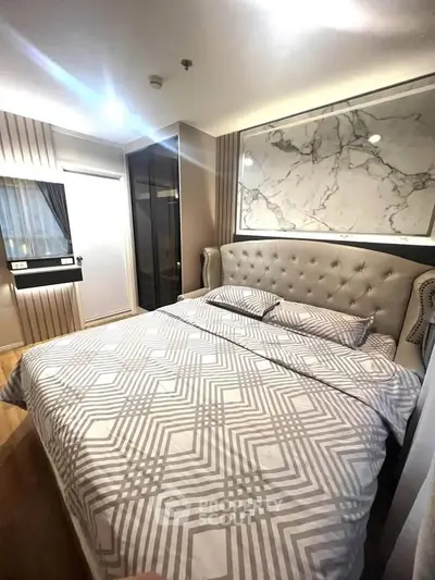 Luxurious bedroom with elegant decor and plush bedding in modern apartment.