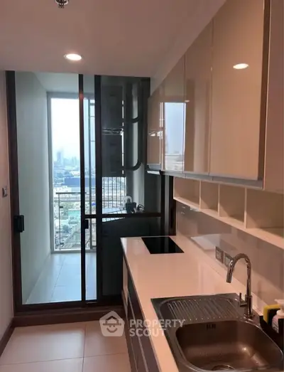 Modern kitchen with sleek cabinets and city view from balcony
