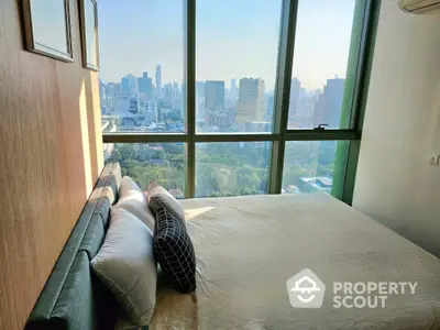 Luxurious bedroom with stunning city skyline view from high-rise window.