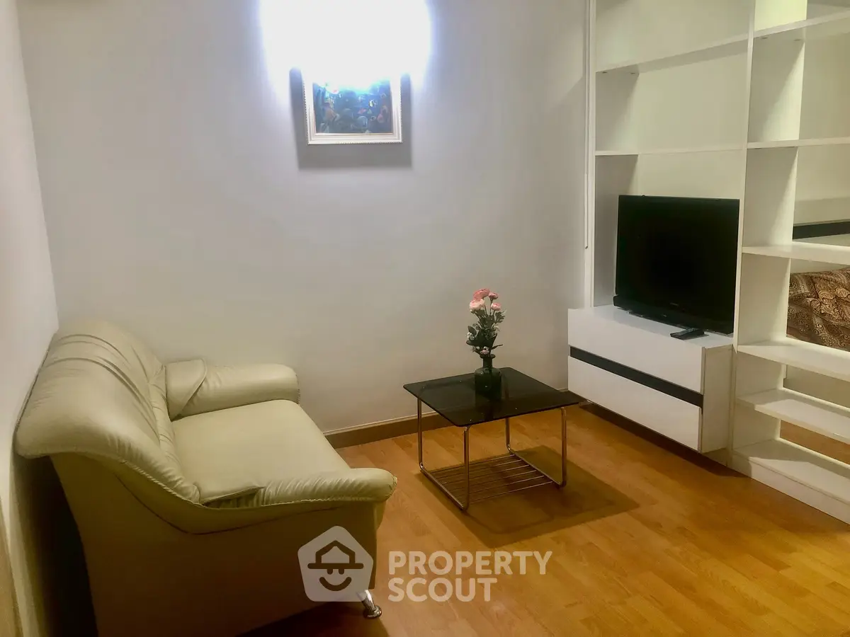 Cozy living room with modern decor, featuring a comfortable sofa, sleek TV unit, and elegant shelving.