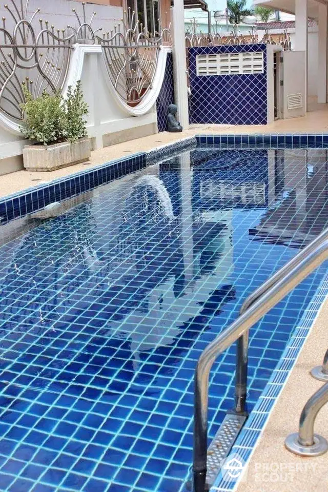 Luxurious private pool with elegant tile design and modern railing in a serene outdoor setting.