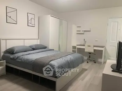 Modern bedroom with stylish decor and workspace, featuring a comfortable bed and sleek furniture.