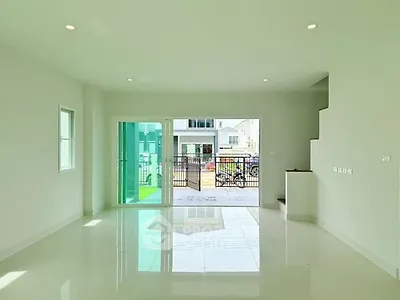Spacious modern living room with large windows and glossy floors