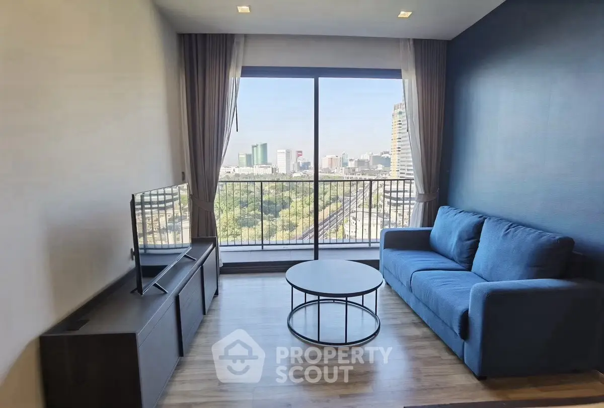 Modern living room with stunning city view and stylish blue sofa.