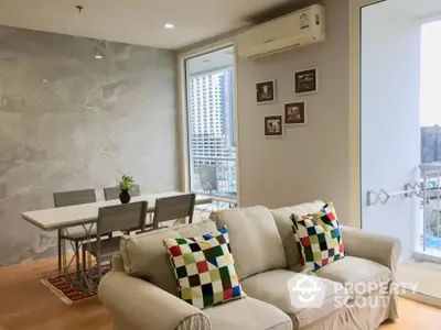 Modern living room with city view, stylish sofa, and dining area in open layout apartment.