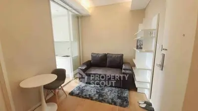Cozy living room with modern sofa, stylish shelves, and compact dining area in a contemporary apartment.