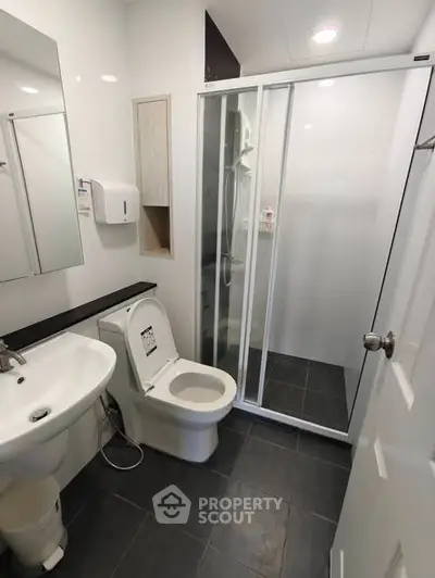 Modern bathroom with sleek shower and contemporary fixtures in a stylish real estate property.