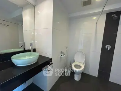 Modern bathroom with sleek design featuring a vessel sink and contemporary fixtures.