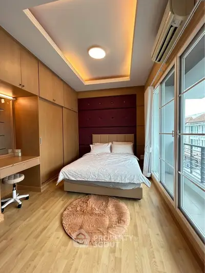 Spacious bedroom with modern design and large windows offering natural light and city views.