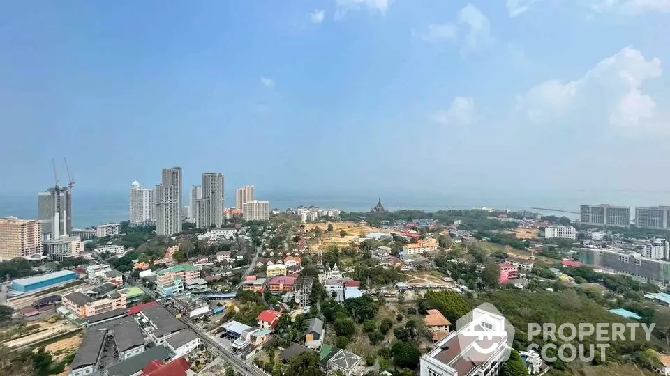 Stunning panoramic view of coastal cityscape with high-rise buildings and ocean horizon.