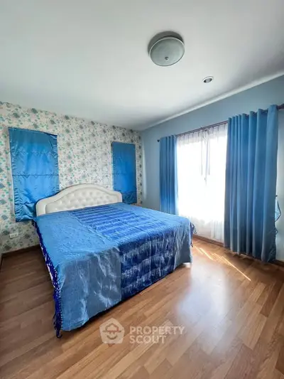 Spacious bedroom with elegant blue decor and natural light