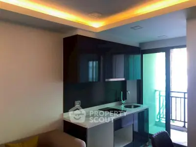 Modern kitchen with sleek cabinets and balcony access in a stylish apartment.