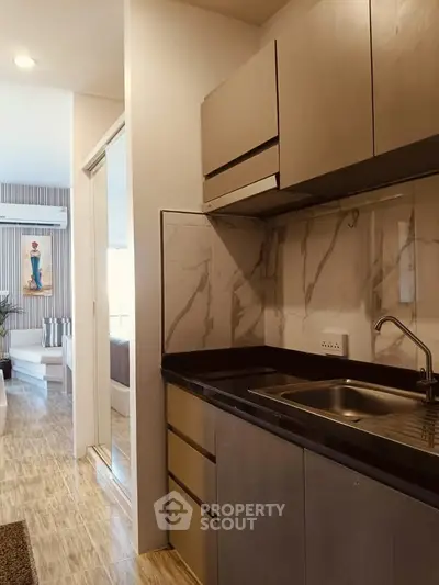 Modern kitchen with sleek cabinetry and marble backsplash in a stylish apartment.