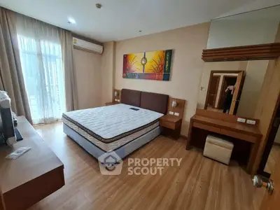 Spacious bedroom with modern decor and large window in a stylish apartment.