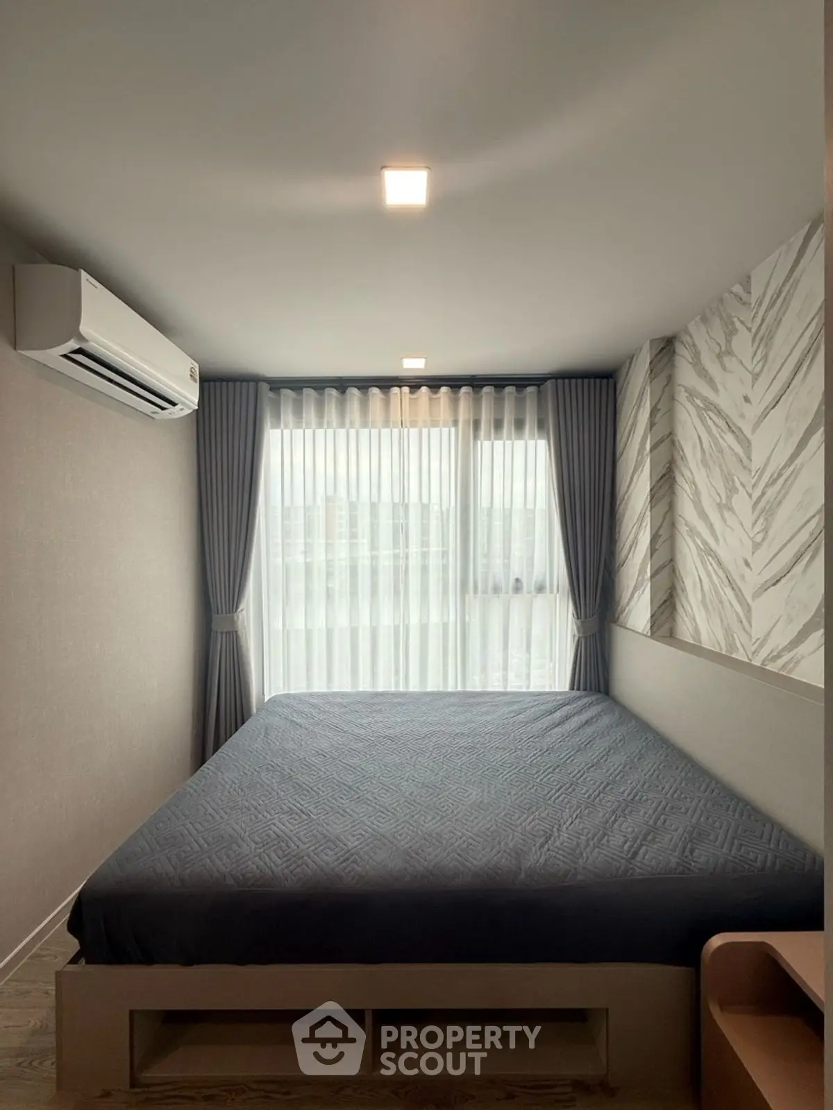 Modern bedroom with stylish decor and large window for natural light.