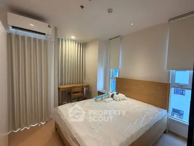 Modern bedroom with wooden bed frame, air conditioning, and natural light from large windows.