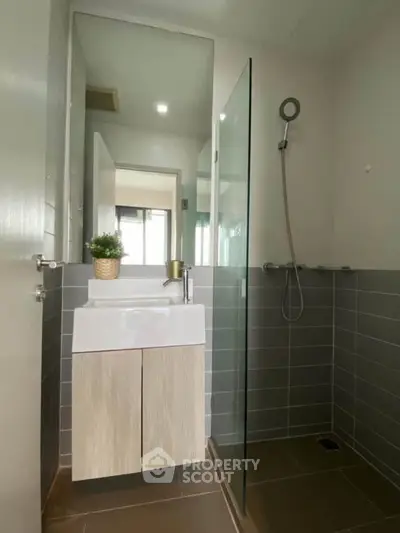 Modern bathroom with sleek design, featuring a glass shower and stylish vanity.