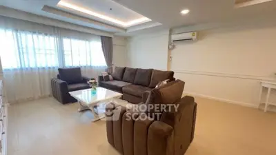 Spacious living room with modern brown sofas and natural light