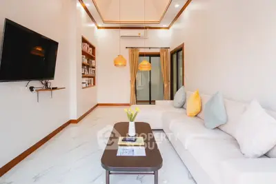 Modern living room with sleek design, cozy white sofa, and wall-mounted TV, perfect for relaxation and entertainment.