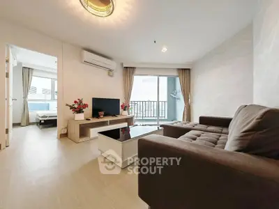 Spacious modern living room with balcony and natural light in a high-rise apartment.