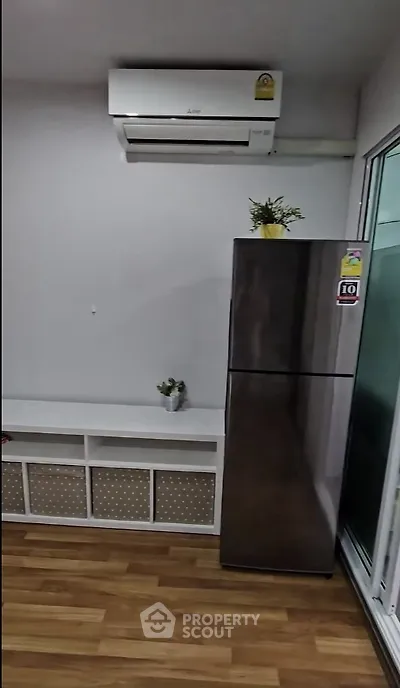 Modern kitchen with sleek fridge and air conditioning unit, perfect for comfortable living.
