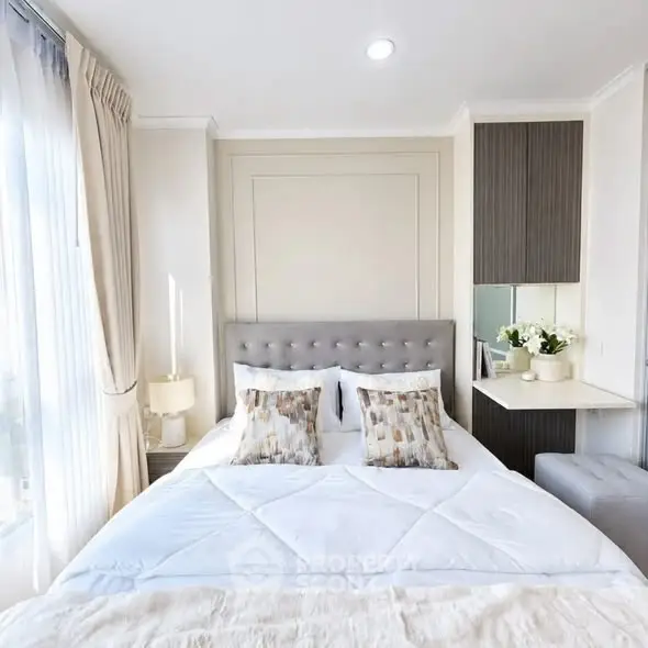 Elegant bedroom with plush bedding and natural light in modern apartment