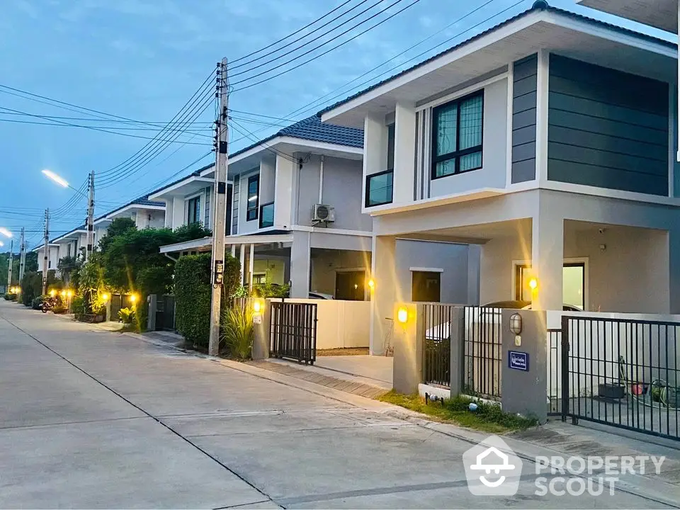 Modern suburban homes with sleek design and well-lit exteriors on a quiet street.