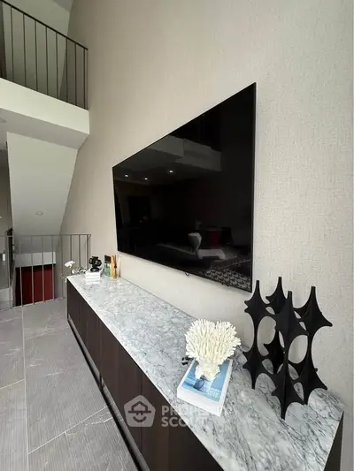 Modern living room with sleek TV and stylish decor on marble console.