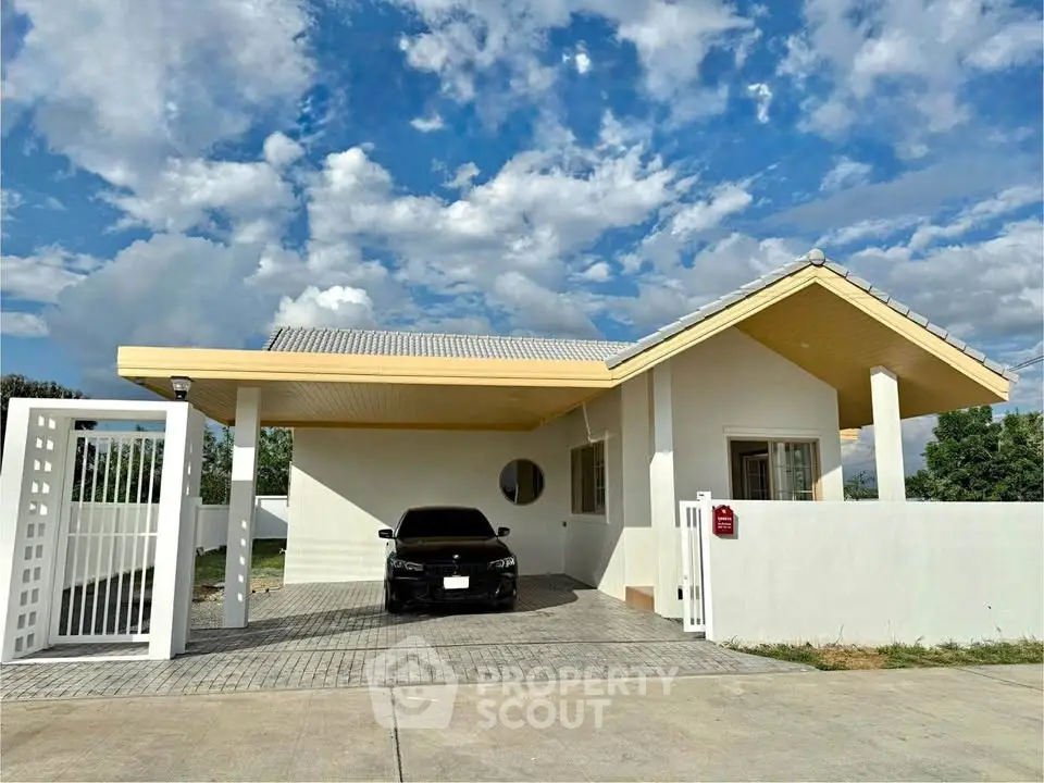 Charming single-story house with carport under a vibrant blue sky, perfect for modern living.