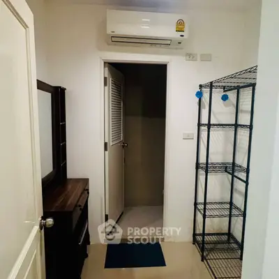 Compact storage room with air conditioning and shelving unit, ideal for organizing essentials.