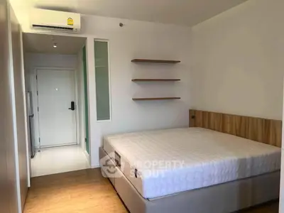 Modern bedroom with minimalist design featuring a comfortable bed and sleek wooden flooring.