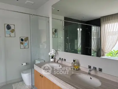 Luxurious modern bathroom with dual sinks and glass shower enclosure
