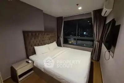 Cozy bedroom with city view, featuring a plush bed and modern decor, perfect for restful nights.