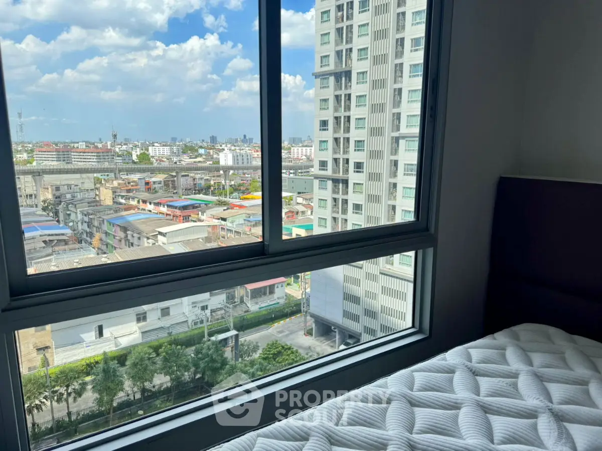 Stunning city view from a modern high-rise apartment bedroom window, showcasing urban living at its finest.